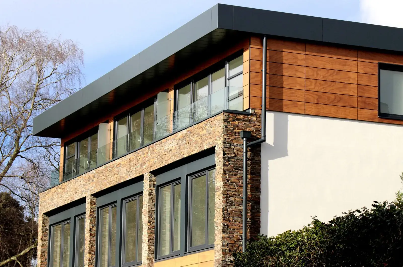 House exterior clad in stone and wood with large windows